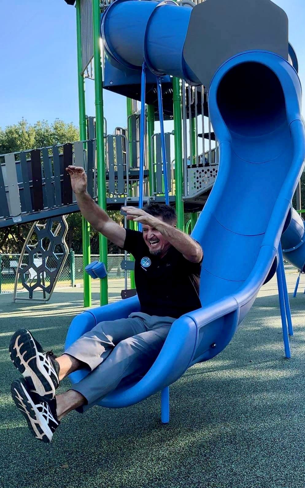 John Allen on Slide with arms in the air having fun