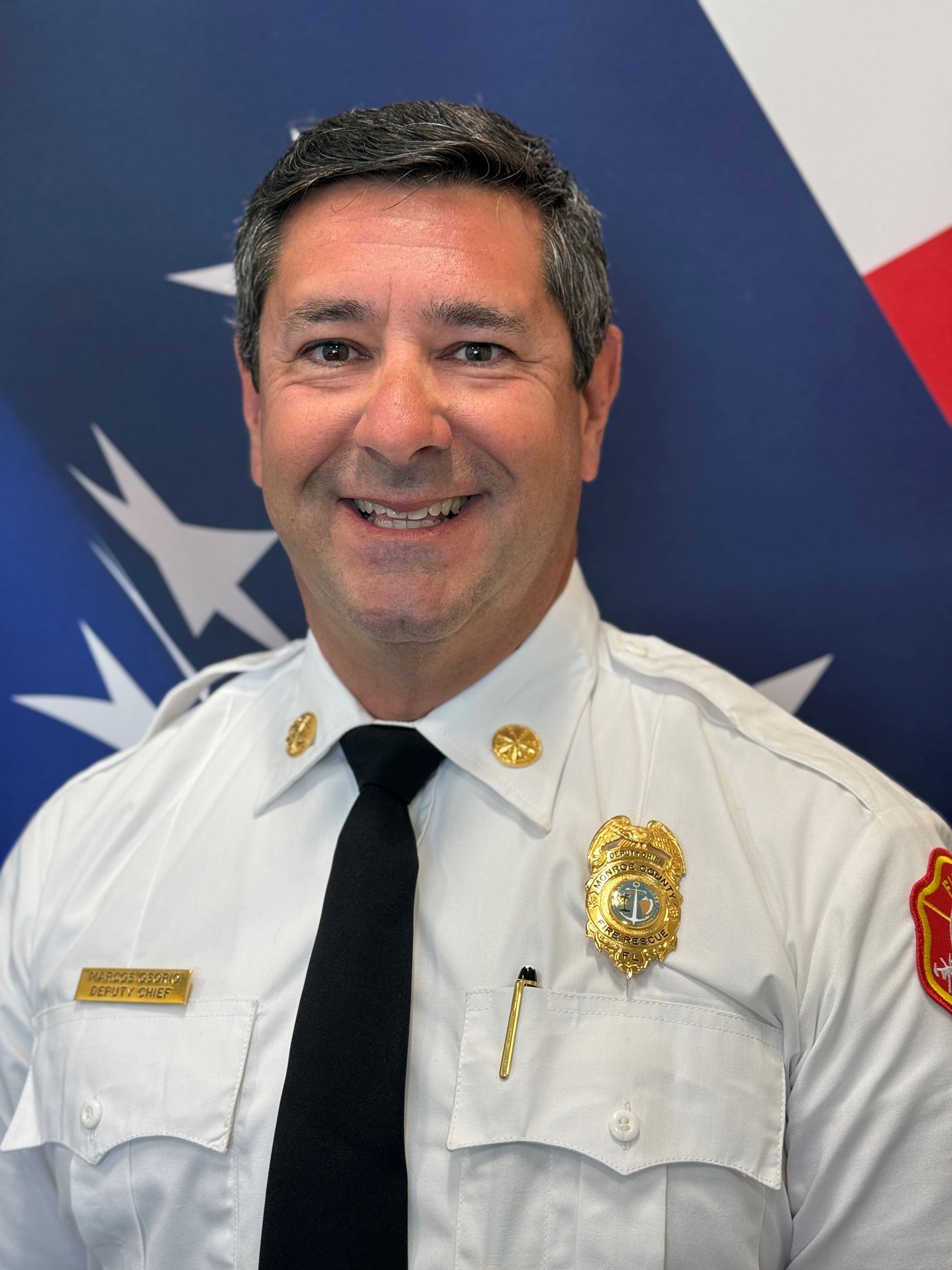 Headshot of Marcos Osorio in front of an American flag